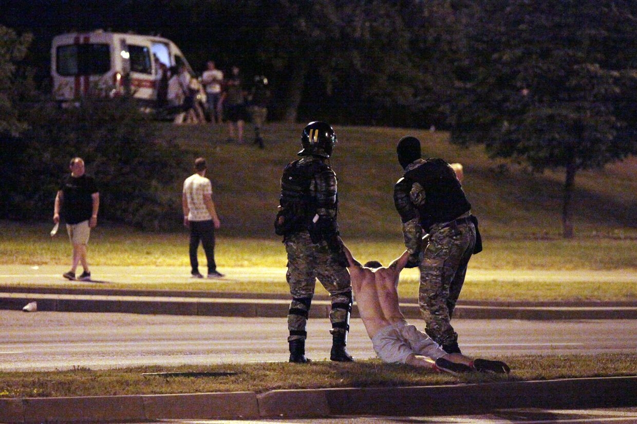 Riot police detain a protester after polls closed in the presidential election, in Minsk on Aug. 9, 2020.