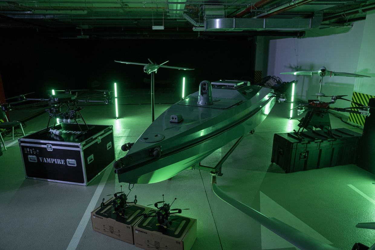 A "Magura"surface combat drone, center, beside aerial drones during a presentation of drone military hardware 
