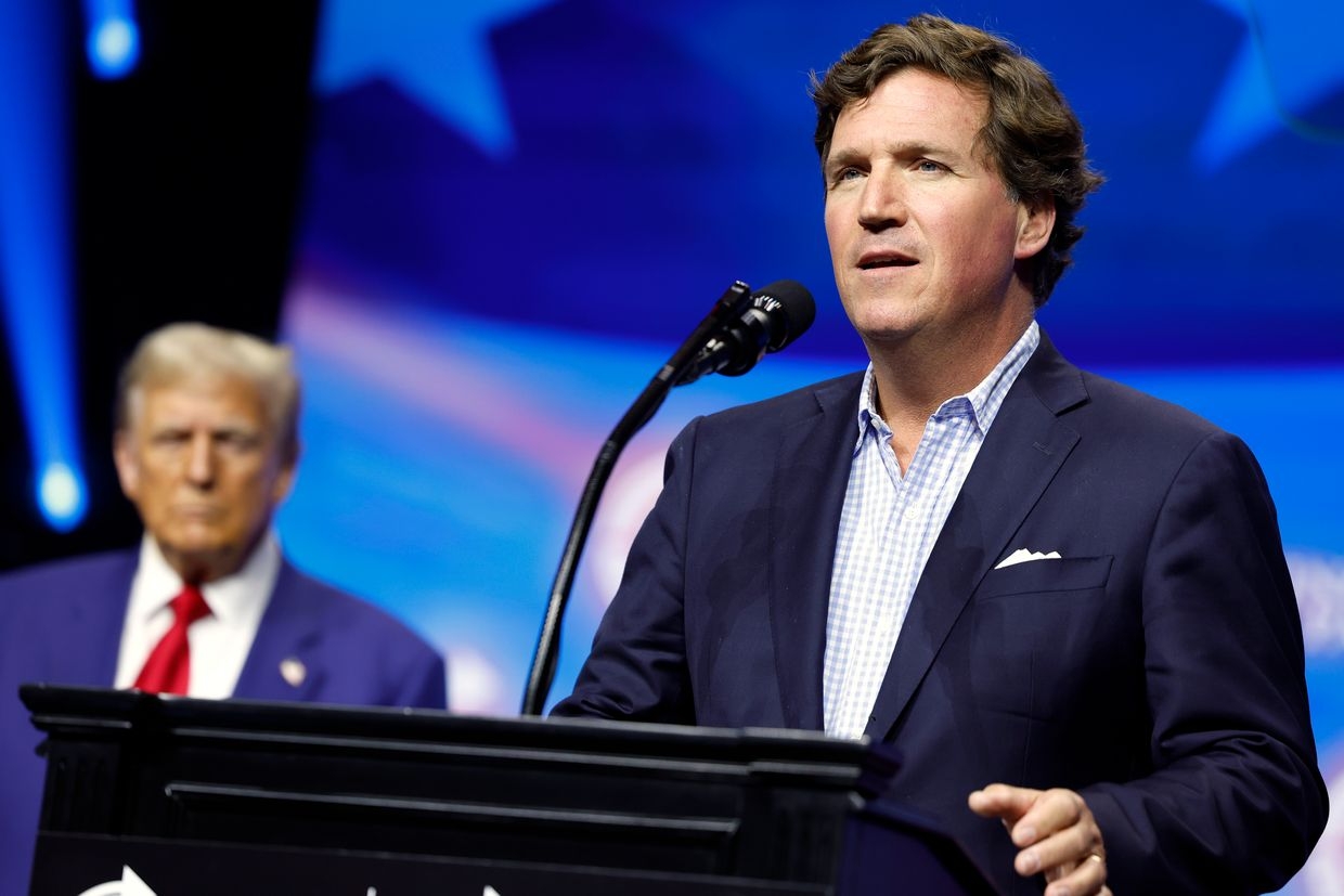 Tucker Carlson speaks with Republican nominee Donald Trump at a Turning Point Action rally in Duluth, Georgia, US, on Oct. 23, 2024.