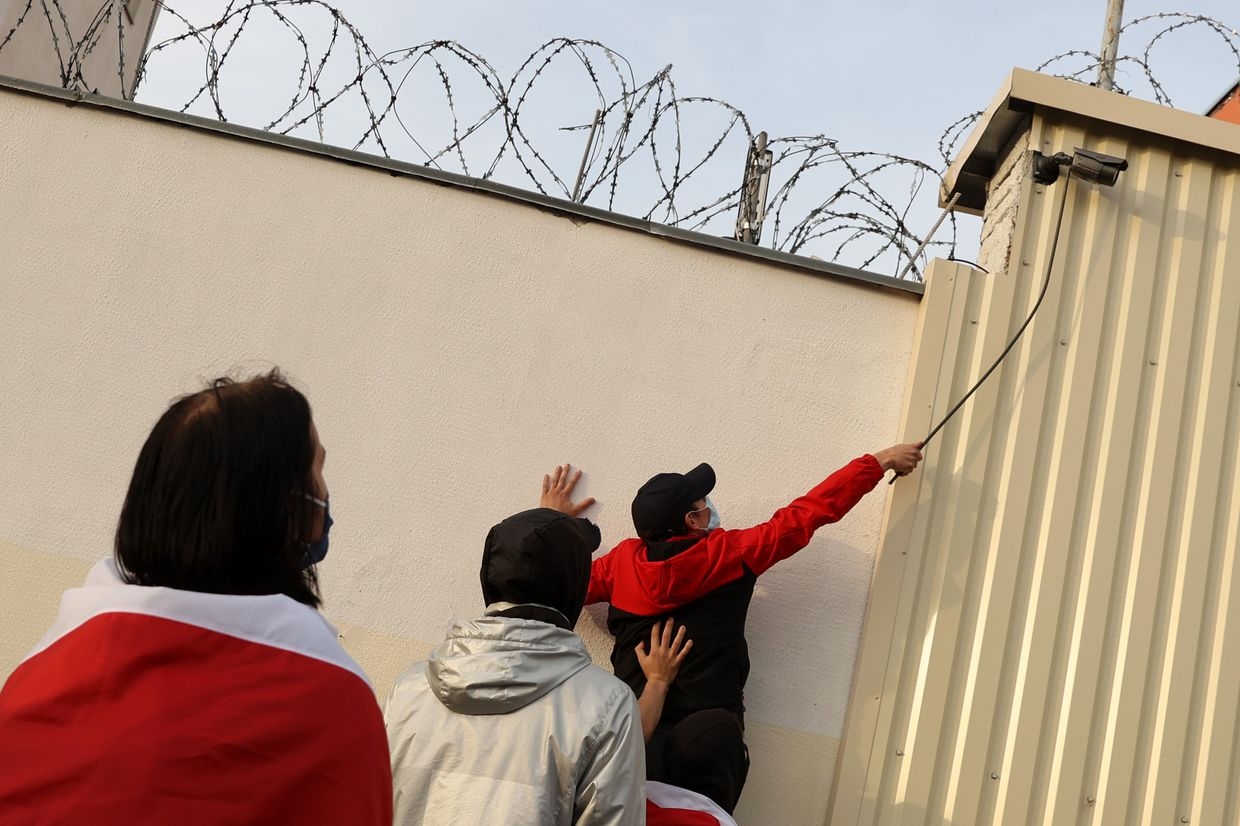  Protesters attempt to dismantle a security camera on Okrestina prison's fence during a rally for jailed activists in Minsk, Belarus, on Oct. 4, 2020.