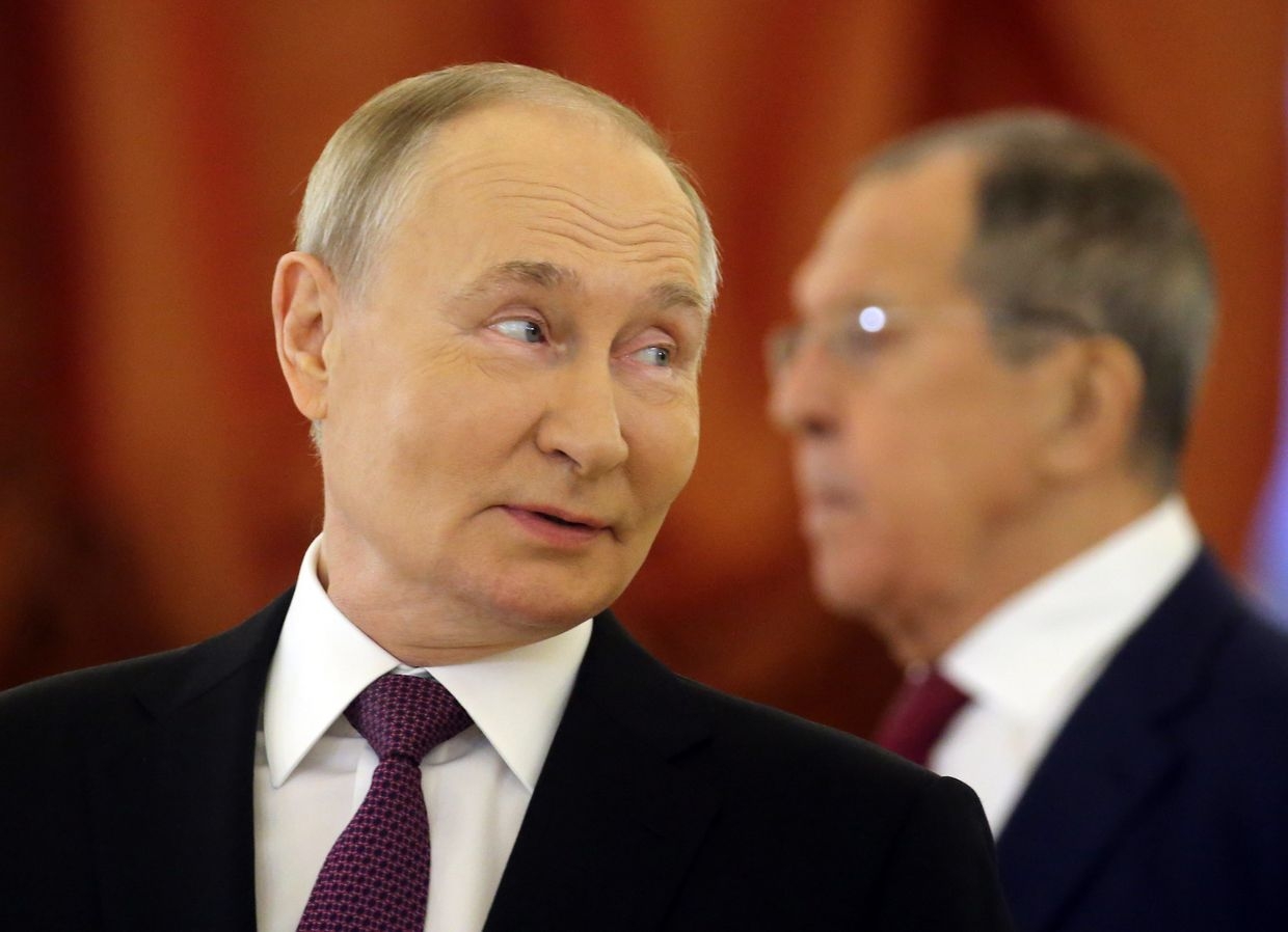 Russian President Vladimir Putin smiles as Foreign Minister Sergey Lavrov looks on during a reception at the Kremlin in Moscow, Russia, Nov. 5, 2024.