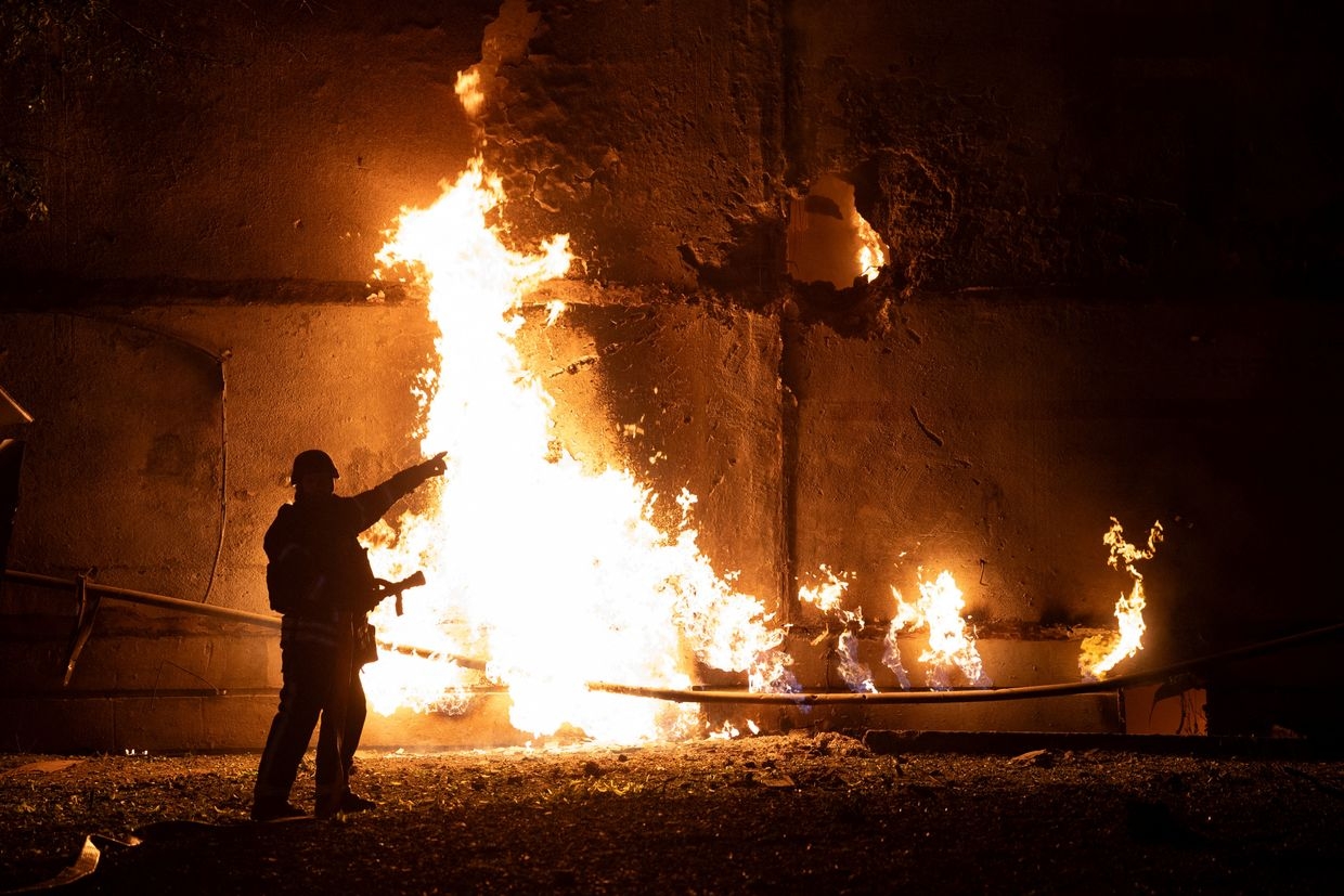 A firefighter stands by a fire and points to a hole after a drone strike in Kharkiv, Ukraine, on June 5, 2025, amid the Russian invasion.