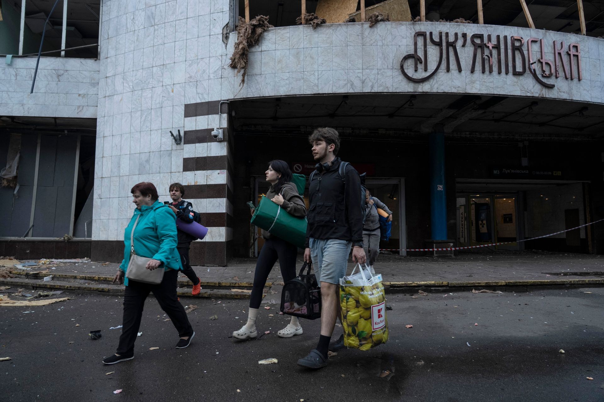 People carry belongings out of a damaged metro station after a Russian attack in Kyiv, Ukraine, on July 21, 2025.