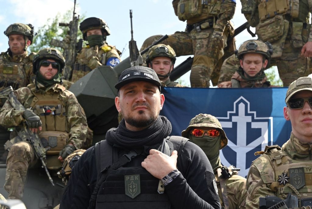 The commander of the Russian Volunteer Corps, Denis (C), known as "White Rex," flanked by fighters in camouflage, attends a presentation for the media in northern Ukraine, not far from the Russian border, on May 24, 2023. (Sergey Bobok/AFP via Getty Images)