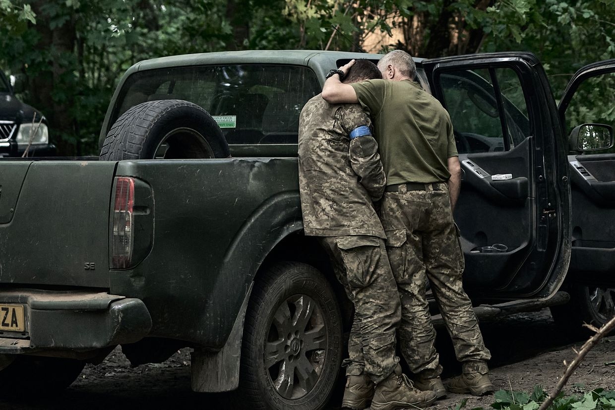 A Ukrainian soldier cries on his comrade's shoulder after returning from Kursk Oblast near the Russian border in Sumy Oblast, Ukraine, on Aug. 14, 2024.