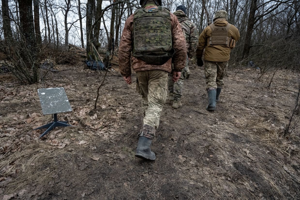 Ukrainian soldiers walk past a Starlink satellite internet receiver in an undisclosed location in Ukraine, on Feb. 18, 2024. (Scott Peterson / Getty Images)