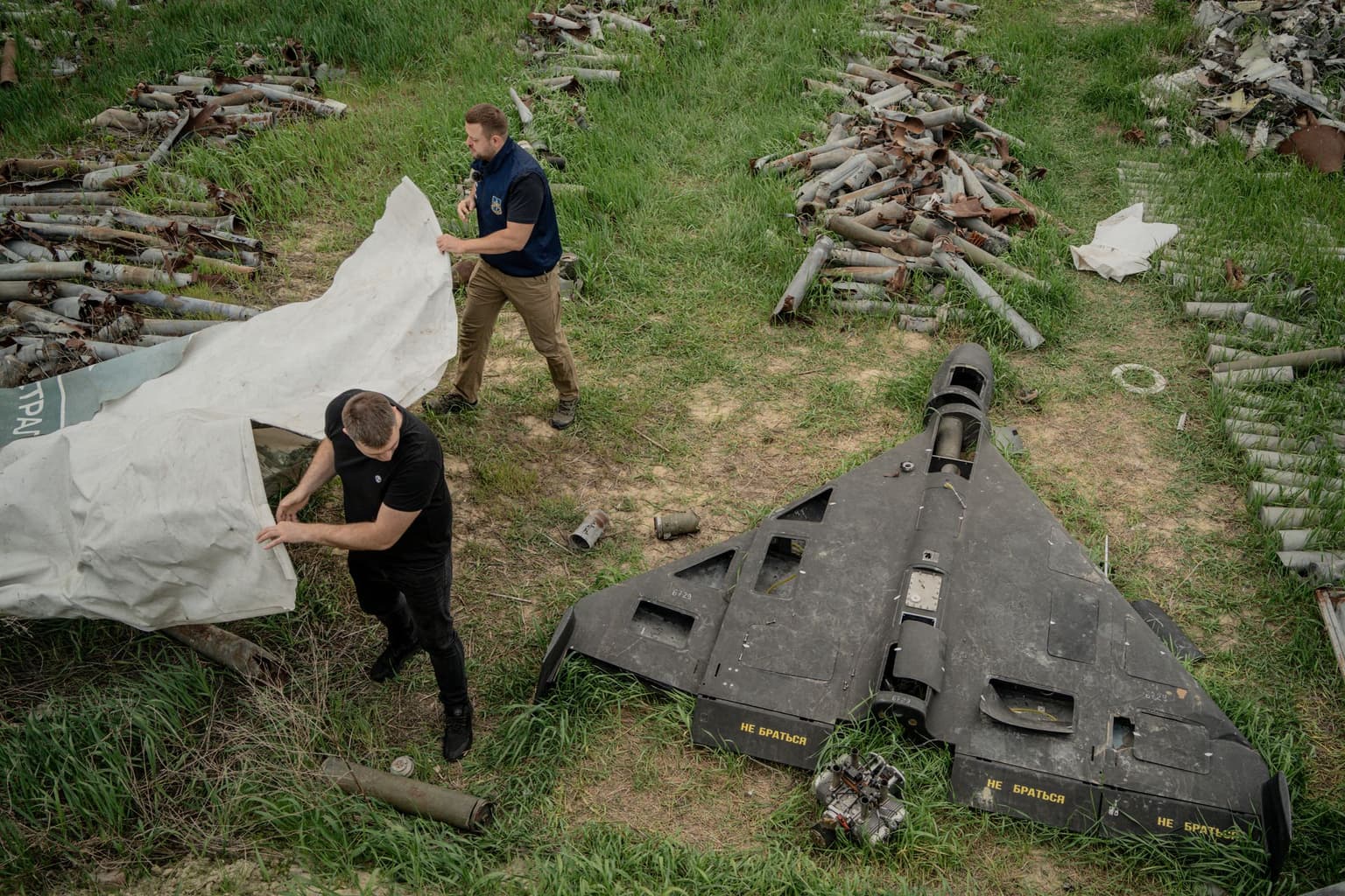 People cover a Russian Shahed drone shot down by Ukrainian air defense in Kharkiv, Ukraine, on April 30, 2025.