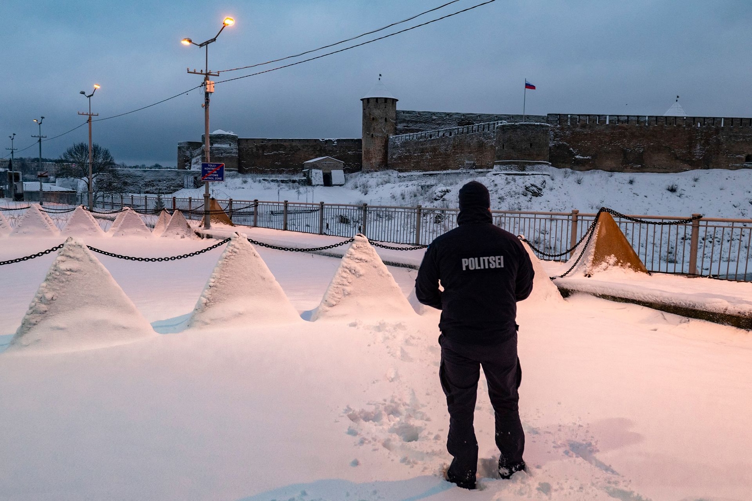 Border Guard stands next to "dragon’s teeth" fortifications, pyramidal anti-tank obstacles, at the Estonian-Russian border in the Narva crossing on Dec. 15, 2024.