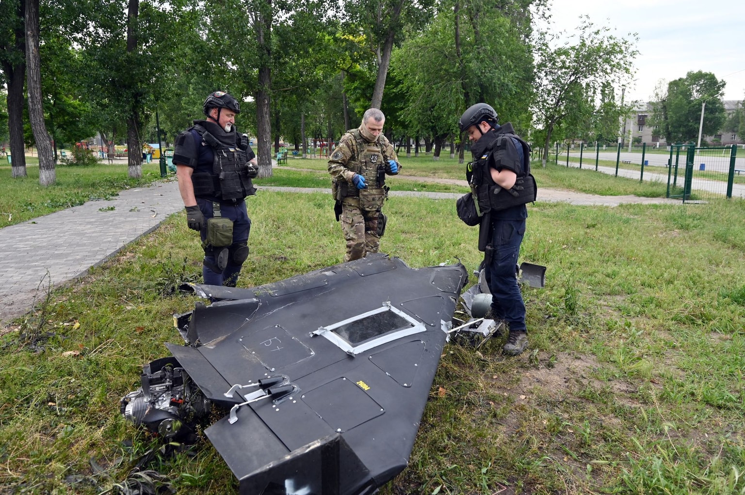 Ukrainian explosives experts and police officers examine parts of a Shahed 136 military drone following an air-attack in Kharkiv on June 4, 2025 (Photo by Sergey Bobok/AFP via Getty Images)