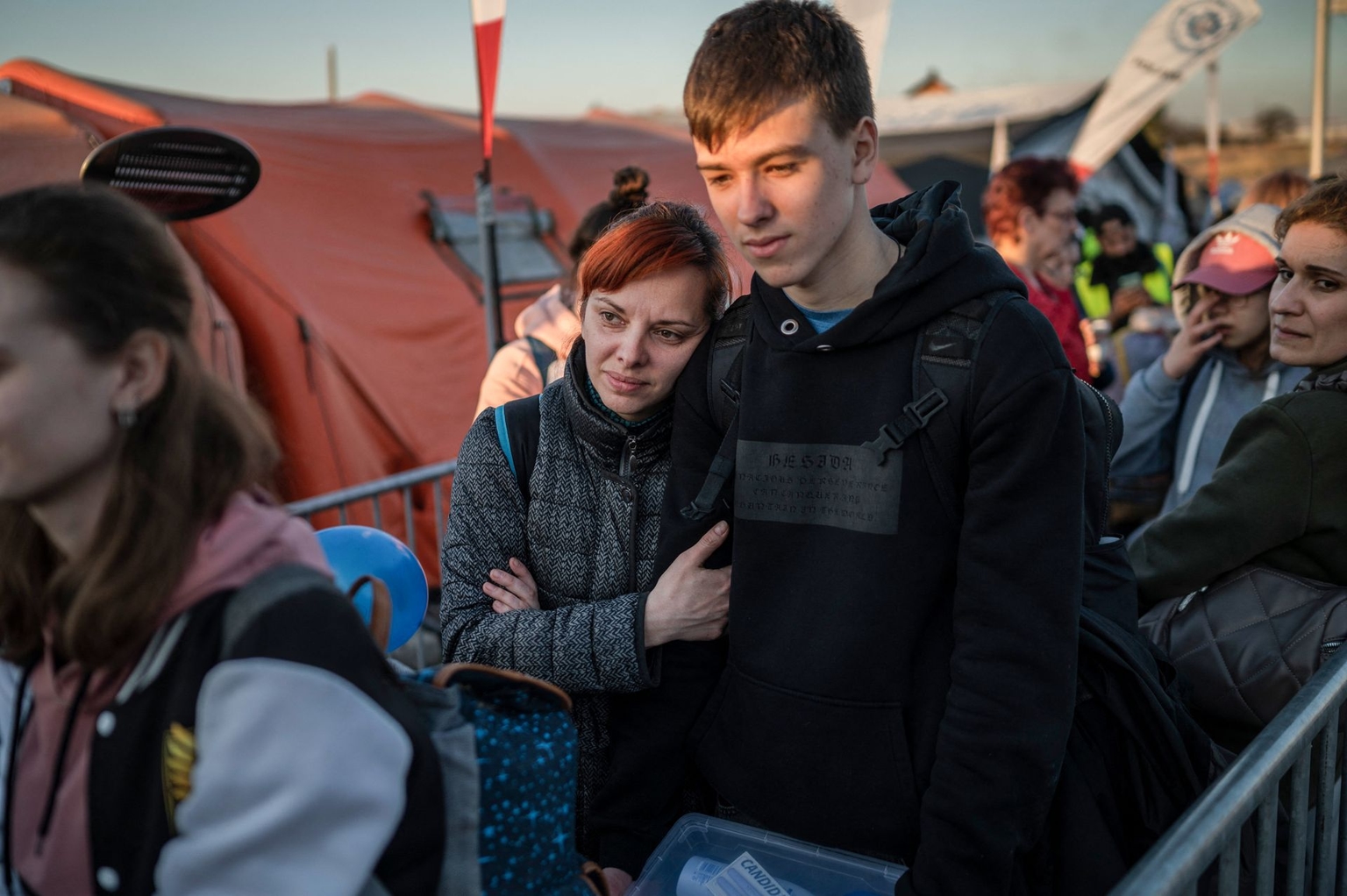 Ukrainian refugees queue while waiting for further transport at the Medyka border crossing in southeastern Poland on March 23, 2022