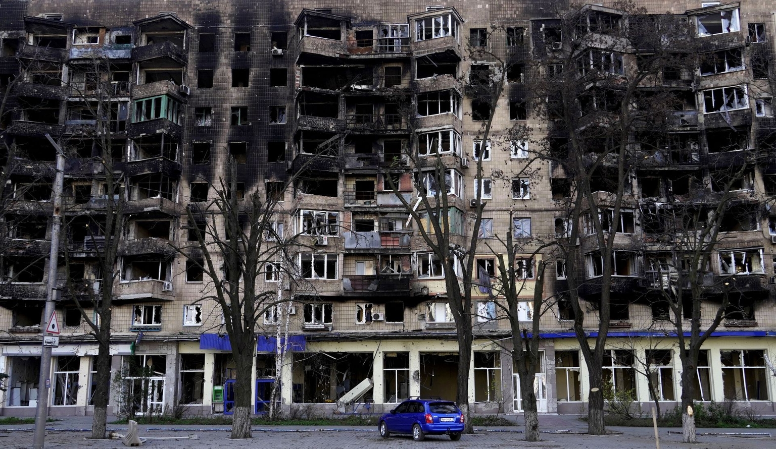 A car stands in front of a damaged building in the Russian-occupied port city of Mariupol, Ukraine, on Nov. 29, 2022.