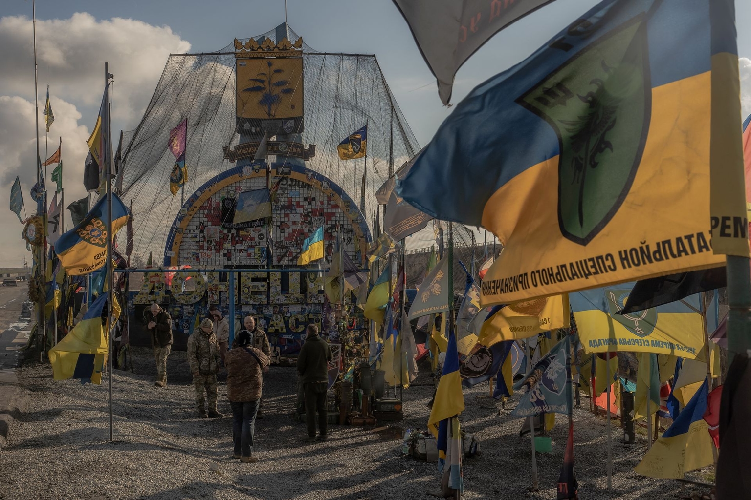 Ukrainian soldiers at the entrance sign to Donetsk Oblast surrounded Ukrainian brigade flags