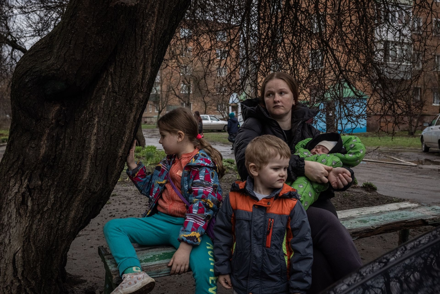 Olha Rud, 29, from Krasnopillia village, sits with her children, Liza, 6, Yehor, 3, and Artem, born on March 5, outside an evacuation center after being evacuated and preparing to stay with relatives in Sumy, Ukraine, on April 2, 2025.