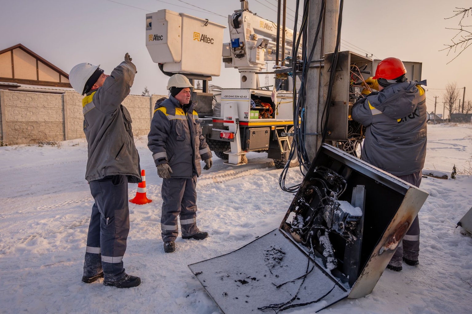 Electricians from DTEK inspect damaged equipment on an electricity pylon in Kyiv Oblast, Ukraine, on Jan. 14, 2026. (