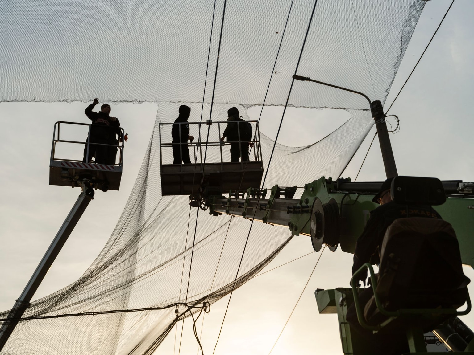 Workers install anti-drone netting over a street in Kherson, Ukraine, on Nov. 21, 2025.