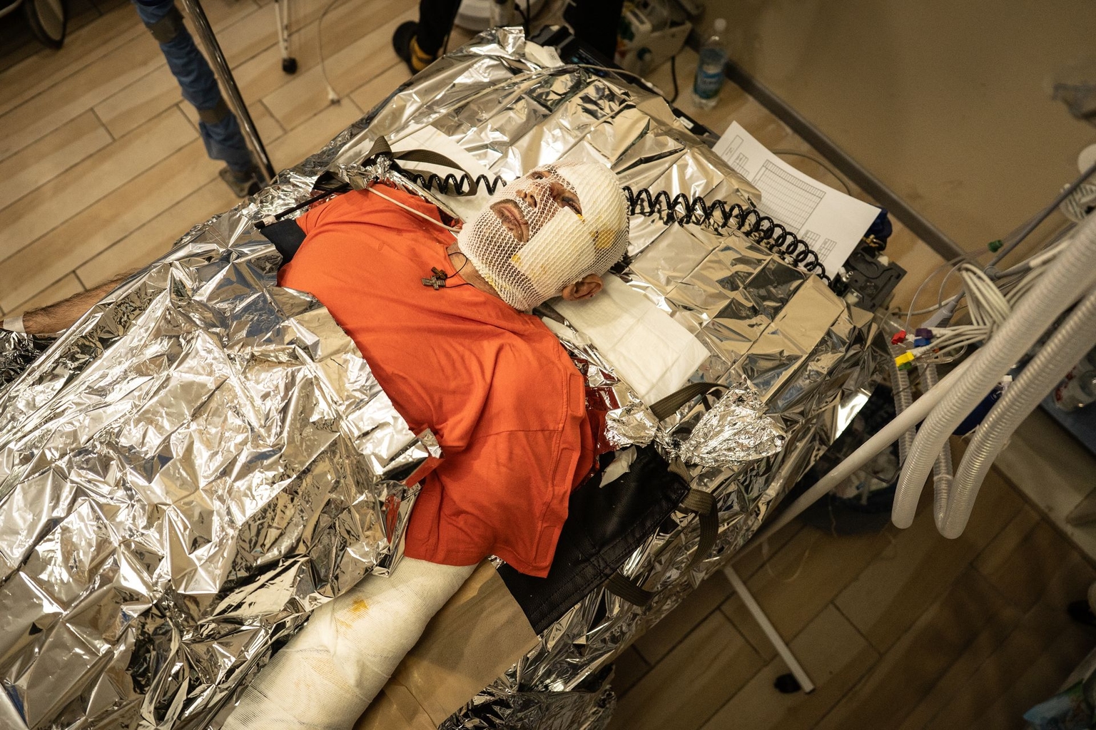 A wounded soldier lies on a stretcher wrapped in thermal blankets while receiving treatment at a medical facility operated by Ukraine’s First Medical Battalion near the front line in Donetsk Oblast on Jan. 24, 2026.