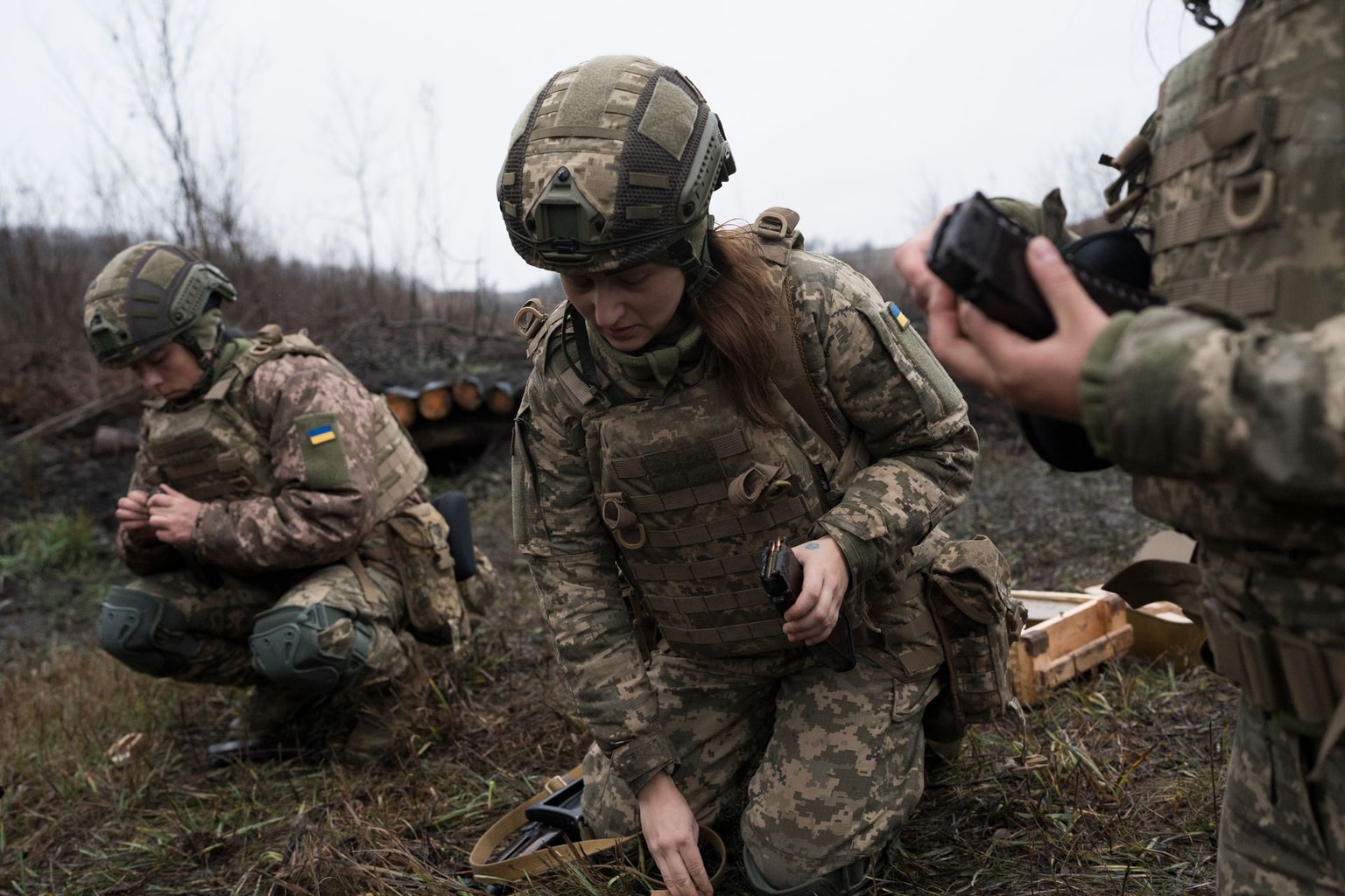 Newly minted female soldiers reload their magazines. Female former inmates turned Ukrainian servicewomen march across a prison yard during their transition from incarceration to military service near the front lines in Ukraine, 13 January 2026. (Nadia Karpova/Frontliner/Getty Images)