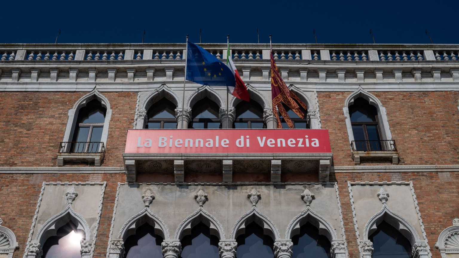 A Venetian Gothic facade adorned with banners for the 2026 Venice Biennale, in Venice, Italy, on Feb. 25, 2026.