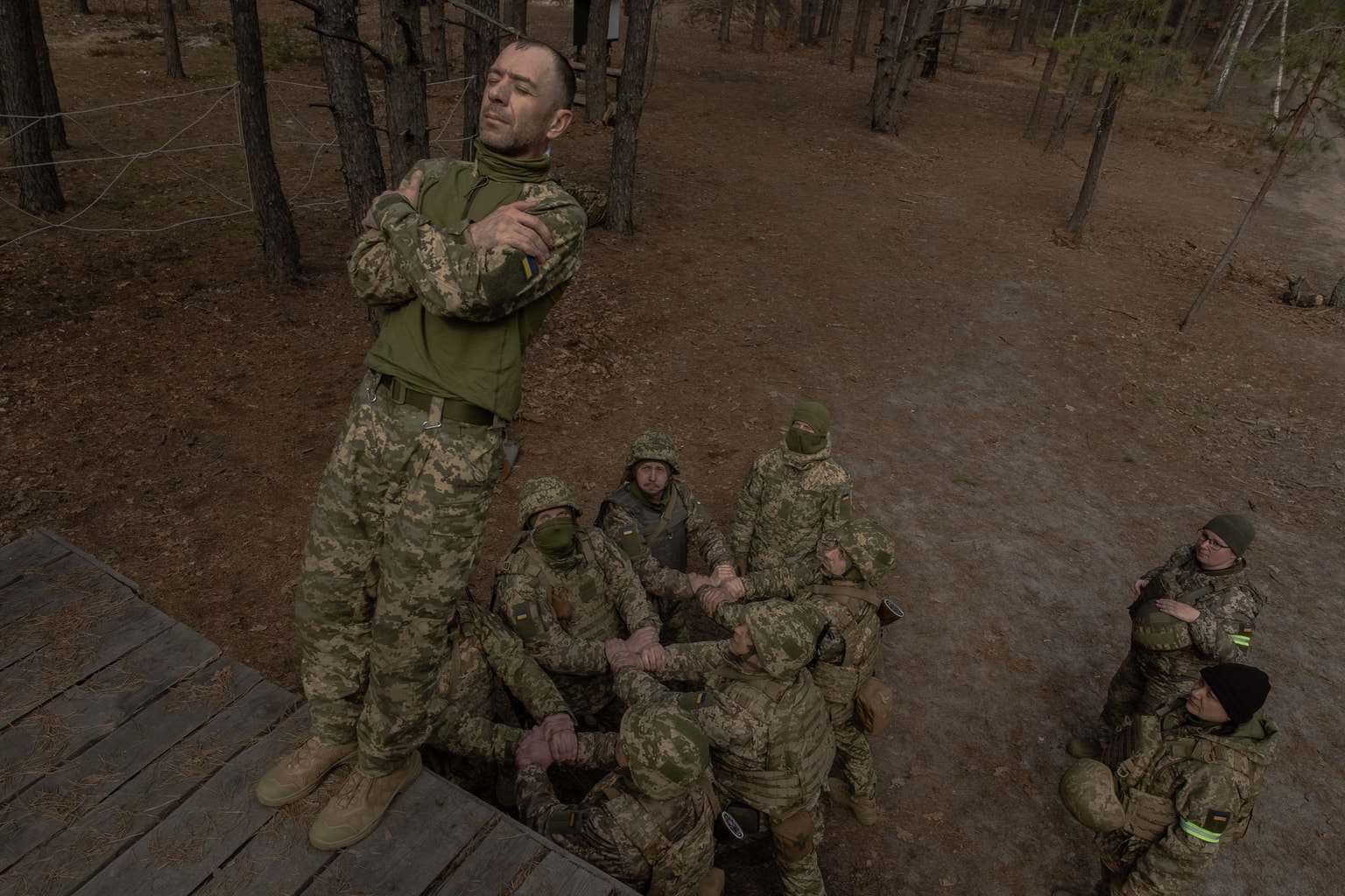 A Ukrainian recruit falls as his fellow soldiers prepare to catch him during basic military training at a Ukrainian Ground Forces training center in an undisclosed location, Ukraine, on March 25, 2026. (Roman Pilipey / AFP / Getty Images)