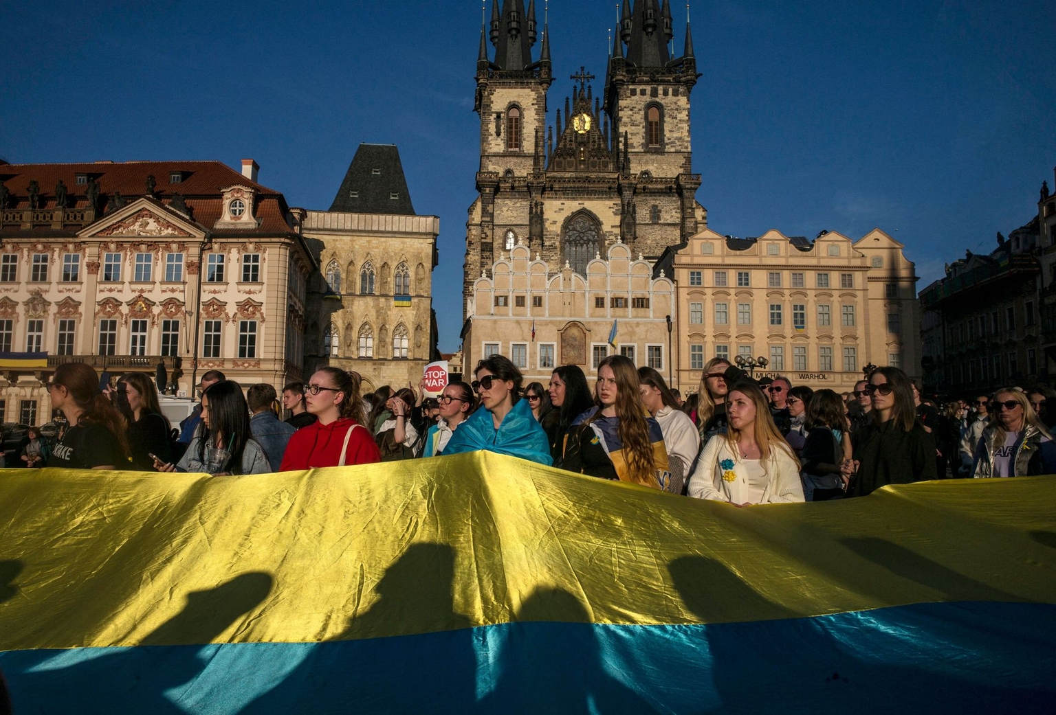 People wave a Ukrainian flag while watching a charity concert in Prague, Czechia, on March 27, 2022.