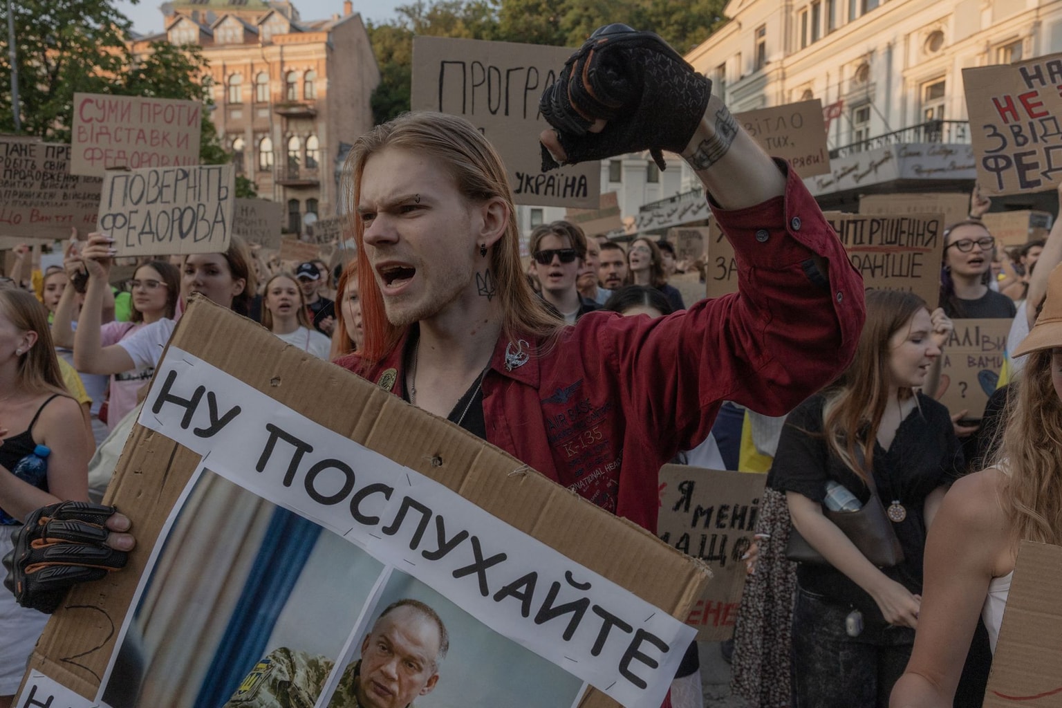 A protester hold a placard reading "Bring back Fedorov" and a portrait of Oleksandr Syrskyi, Commander-in-Chief of Ukraine's Armed Forces during a demonstration against Ukraine's President Volodymyr Zelensky's decision to dismiss Ukraine's former defence minister Mykhailo Fedorov, in Kyiv on July 16, 2026. (Roman Pilipey / AFP via Getty Images)