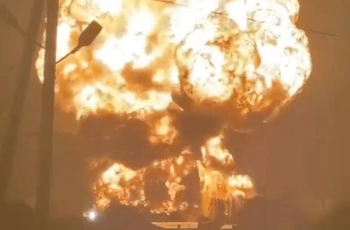 A bright explosions erupts, lighting up the night sky