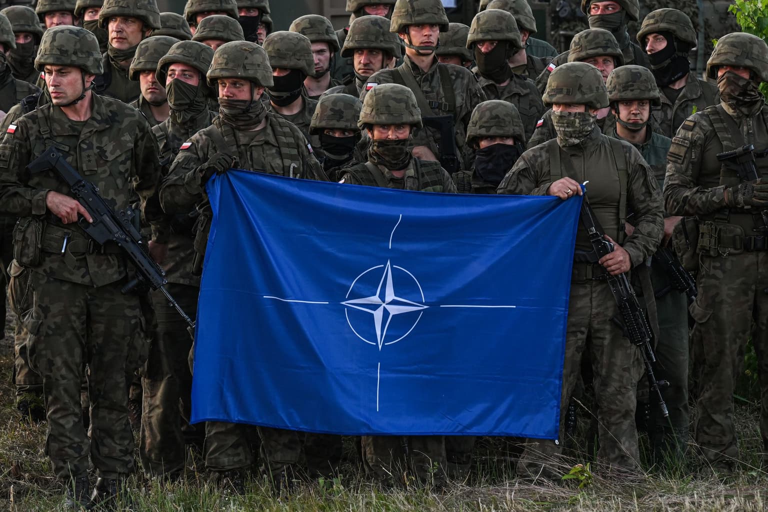 Polish soldiers hold a NATO flag at the Orzysz training ground in Orzysz, Poland, on July 3, 2022.