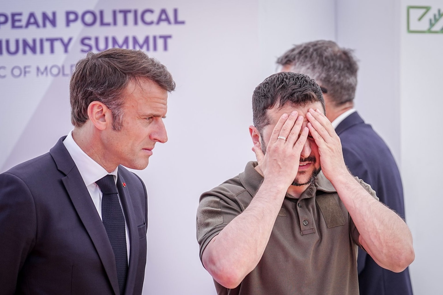 President Volodymyr Zelensky clutches his head next to French President Emmanuel Macron at the European Political Community (EPC) summit in Moldova, June, 1, 2023. (Kay Nietfeld/picture alliance via Getty Images)