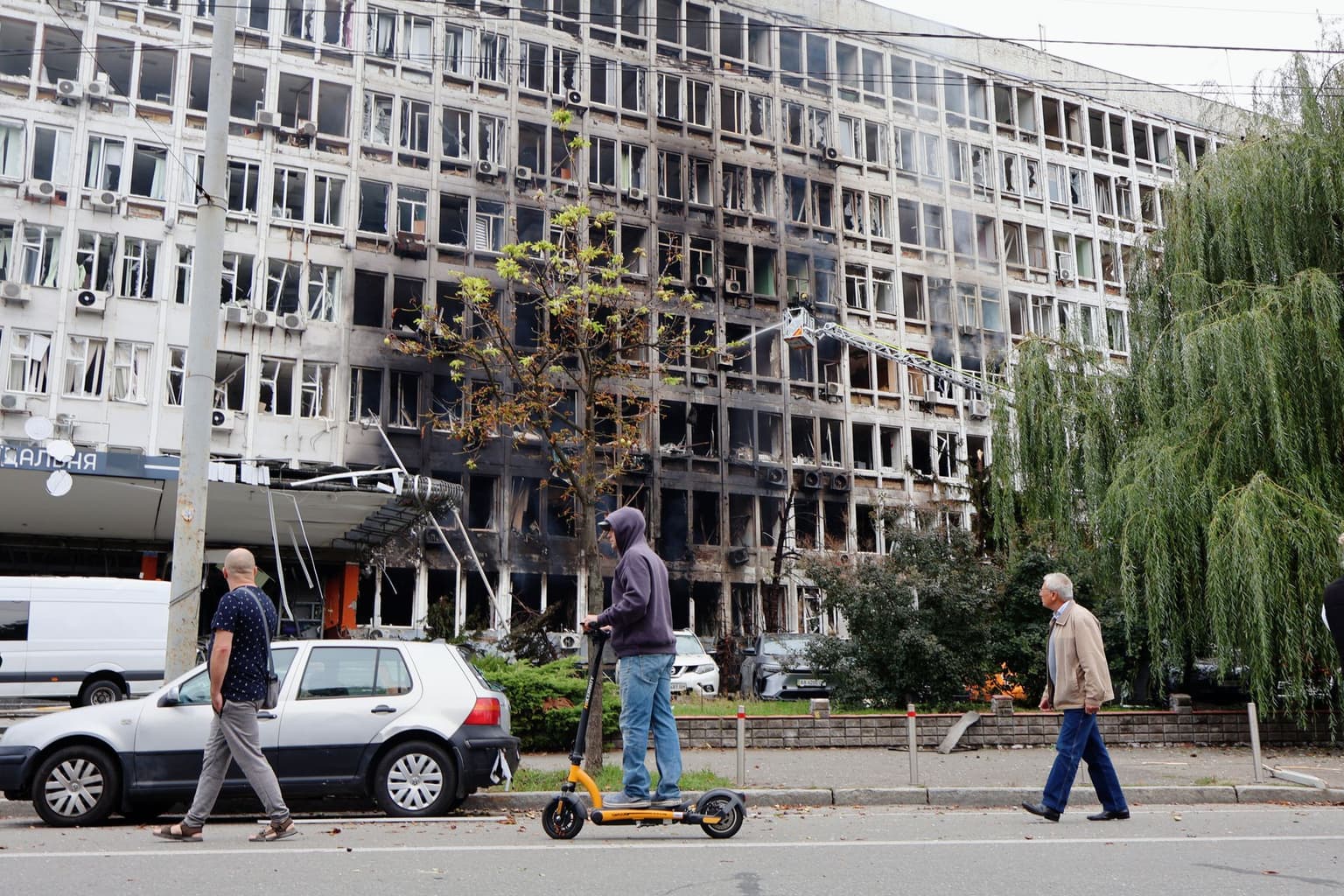 People walk past a building damaged by a Russian drone strike in Kyiv, Ukraine, on Sept. 23, 2026.