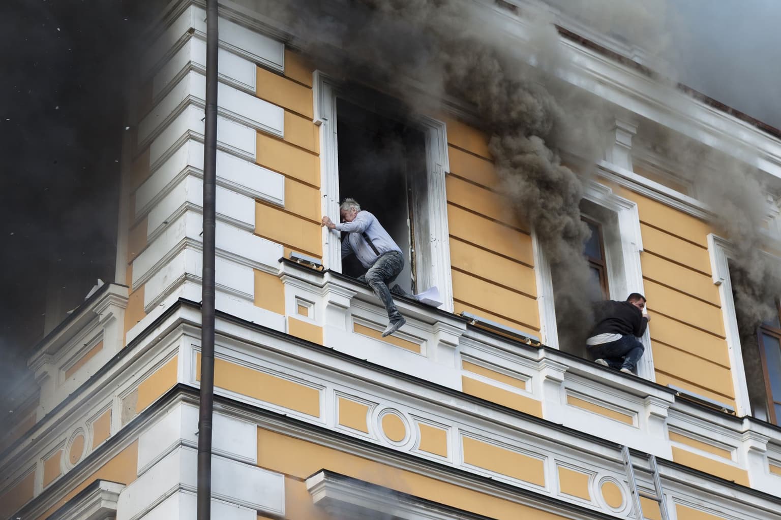 Two men escape a fire at the National Academy of Sciences building after a Russian drone strike in Kyiv on Sept. 28, 2026.