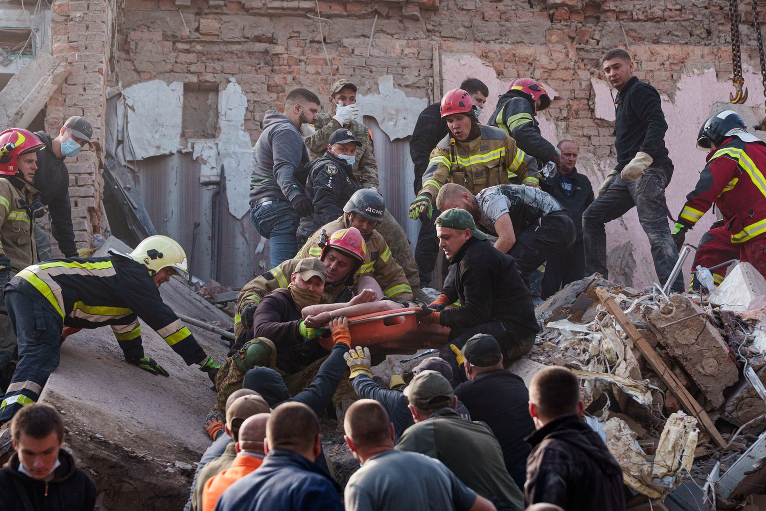 Locals and rescuers carry an injured man from a residential building destroyed in a Russian missile strike in Pryluky, Chernihiv Oblast, Ukraine, on Oct. 7, 2026. (Evgeniy Maloletka / AP)