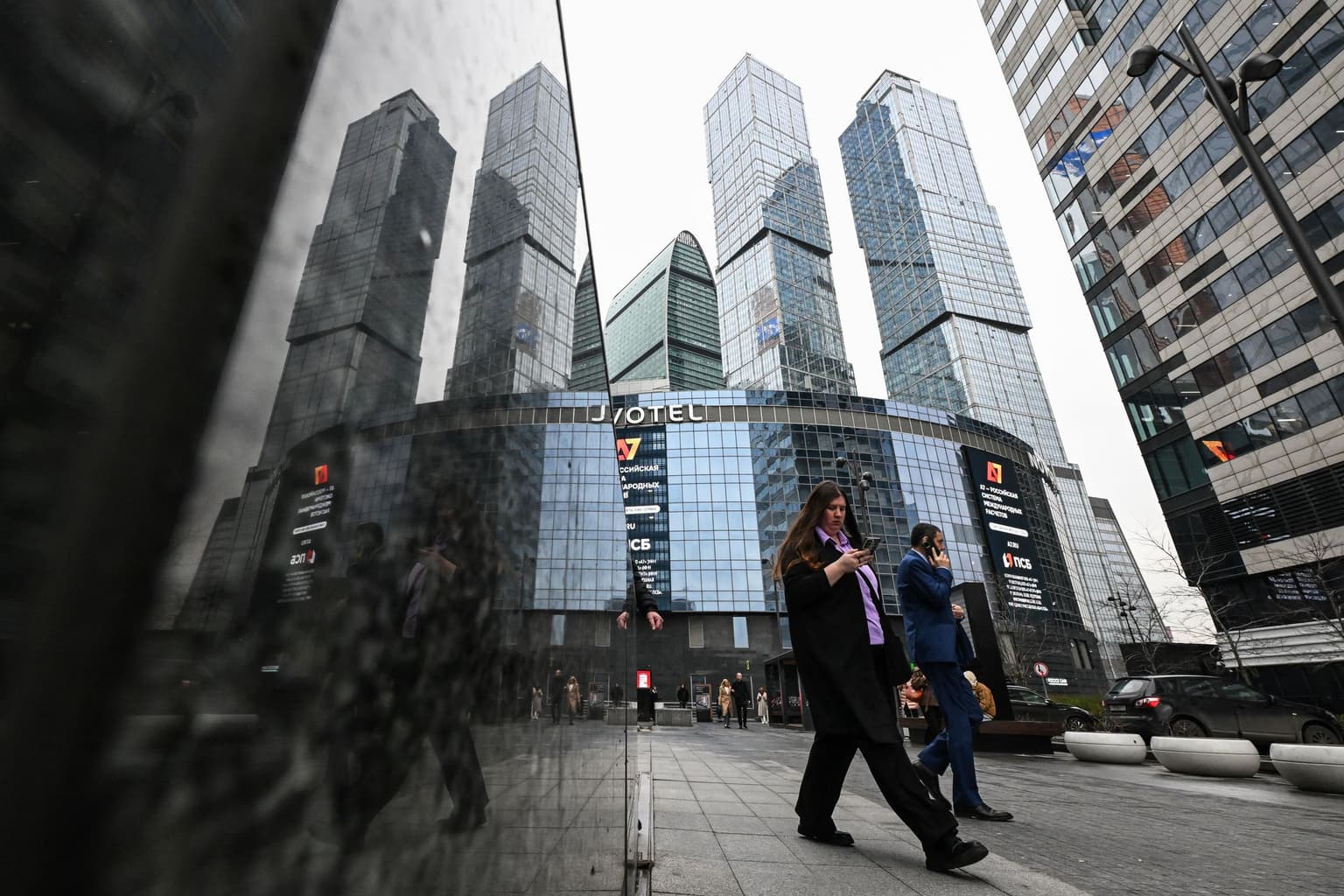 People use mobile phones near the Moscow City business center in Moscow on April 15, 2026.