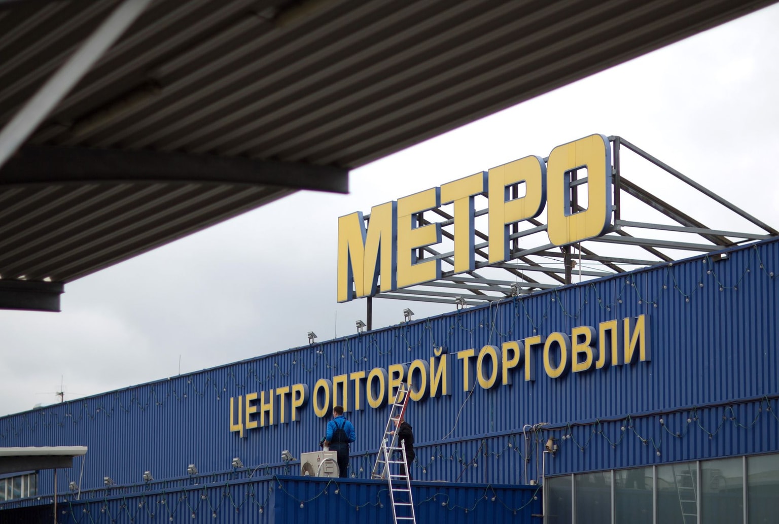 Maintenance workers carry ladders onto the roof of a Metro Cash & Carry store, the Russia unit of Metro AG, in Moscow, Russia, on Aug. 29, 2014. (Andrey Rudakov/Bloomberg via Getty Images)